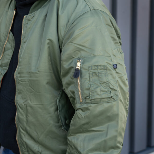 1214011 MA 1 bomber jack20 <strong>Materiaal:</strong> 100% hoogwaardig nylon ✔ <strong>Warme gewatteerde jas</strong> met binnenvoering ✔ <strong>Metalen ritssluiting</strong> voor extra duurzaamheid ✔ <strong>Twee steekzakken met drukknoop</strong> op de voorzijde ✔ <strong>Armzakje met metalen rits</strong> voor kleine accessoires ✔ <strong>Omkeerbare oranje binnenvoering</strong> voor extra zichtbaarheid ✔ <strong>Lage kraag</strong> voor een tijdloze look ✔ <strong>Verkrijgbaar in XXS t/m XXL</strong>, inclusief <strong>XS voor tieners vanaf 15 jaar</strong> <strong>Gewicht:</strong> 900 g <strong>Merk:</strong> Fostex Garments <strong>Perfect voor:</strong> <ul> <li>Beveiligingspersoneel & outdoor activiteiten</li> <li>Fans van militaire stijl & urban fashion</li> <li>Bescherming tegen kou en wind in alle seizoenen</li> <li>Streetwear en casual looks</li> </ul> Met zijn <strong>authentieke ontwerp</strong>, <strong>functionaliteit</strong> en <strong>tijdloze stijl</strong> is de <strong>MA-1 bomber jacket</strong> een must-have voor zowel militaire liefhebbers als modebewuste dragers! Voor de dames is het belangrijk om waarschijnlijk 1 maat kleiner te bestellen. <div><strong>Twijfel je over de maat, bestel dan één maatje groter. De jas valt wat kleiner uit.</strong></div> <div><a title="Maattabel" href="https://dump.dev.newagents.nl/wp-content/uploads/2025/01/Bomber-jas-dump.dev.newagents.nl_.pdf" target="_blank" rel="noopener noreferrer"><button><span style="color: #ef471f; font-size: medium;"><strong>Maattabel</strong></span></button></a></div>