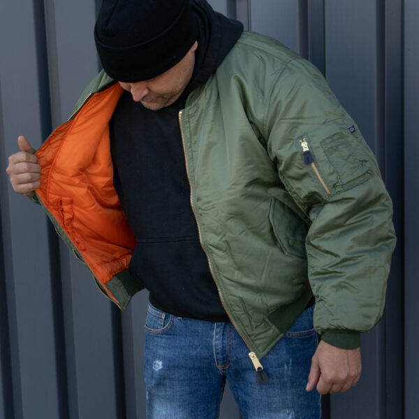 1214011 MA 1 bomber jack21 <strong>Materiaal:</strong> 100% hoogwaardig nylon ✔ <strong>Warme gewatteerde jas</strong> met binnenvoering ✔ <strong>Metalen ritssluiting</strong> voor extra duurzaamheid ✔ <strong>Twee steekzakken met drukknoop</strong> op de voorzijde ✔ <strong>Armzakje met metalen rits</strong> voor kleine accessoires ✔ <strong>Omkeerbare oranje binnenvoering</strong> voor extra zichtbaarheid ✔ <strong>Lage kraag</strong> voor een tijdloze look ✔ <strong>Verkrijgbaar in XXS t/m XXL</strong>, inclusief <strong>XS voor tieners vanaf 15 jaar</strong> <strong>Gewicht:</strong> 900 g <strong>Merk:</strong> Fostex Garments <strong>Perfect voor:</strong> <ul> <li>Beveiligingspersoneel & outdoor activiteiten</li> <li>Fans van militaire stijl & urban fashion</li> <li>Bescherming tegen kou en wind in alle seizoenen</li> <li>Streetwear en casual looks</li> </ul> Met zijn <strong>authentieke ontwerp</strong>, <strong>functionaliteit</strong> en <strong>tijdloze stijl</strong> is de <strong>MA-1 bomber jacket</strong> een must-have voor zowel militaire liefhebbers als modebewuste dragers! Voor de dames is het belangrijk om waarschijnlijk 1 maat kleiner te bestellen. <div><strong>Twijfel je over de maat, bestel dan één maatje groter. De jas valt wat kleiner uit.</strong></div> <div><a title="Maattabel" href="https://dump.dev.newagents.nl/wp-content/uploads/2025/01/Bomber-jas-dump.dev.newagents.nl_.pdf" target="_blank" rel="noopener noreferrer"><button><span style="color: #ef471f; font-size: medium;"><strong>Maattabel</strong></span></button></a></div>