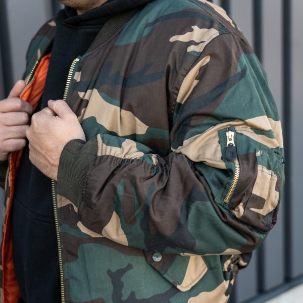 1214031 MA 1 bomber jack camo15 <div class="colordesc"> <big><strong>Fostex Garments® MA-1 Bomber Jack</strong></big> <hr /> <big>Bomber jas Woodland gemaakt van 65% polyester en 35% katoen.</big> <big>Voorzien van een lage kraag en 2 grote steekzakken op de voorzijde. </big> <big>De binnenvoering van de jas is oranje van kleur. Deze opvalllende kleur heeft een reden, zo konden piloten die hulp nodig hadden makkelijk gezien worden door hulptroepen. De jas is dus ook binnenstebuiten te dragen.</big> </div> <div></div> <div><strong>Twijfel je over de maat, bestel dan één maatje groter. De jas valt wat kleiner uit.</strong></div> <div><a title="Maattabel" href="https://dump.dev.newagents.nl/wp-content/uploads/2020/04/deDump.nl-Fostex-MA-1-Bomber-Jack-maattabel.pdf" target="_blank" rel="noopener noreferrer"><button><span style="color: #ef471f; font-size: medium;"><strong>Maattabel</strong></span></button></a></div>