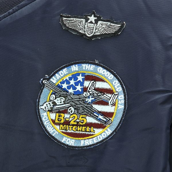 1111121402 MA 1 bomber jack USAF2 Bomber jas Blauw van 100% nylon. De jas is volledig gewatteerd, heeft een voering van polyester en beschikt over meerdere opbergzakken. Wat kenmerkend is aan deze originele en authentieke flight jacket, is dat die voorzien is van 7 geborduurde emblemen. <strong>Geborduurde emblemen:</strong> <ul> <li>B-17 Flying Fortress</li> <li>B-17G Flying Fortress</li> <li>B-25 Mitchell</li> <li>Wing senior pilot</li> <li>US Air Force</li> <li>Amerikaanse vlag</li> <li>Fighting 81</li> </ul> <strong>Twijfel je over de maat, bestel dan één maatje groter. De jas valt wat kleiner uit.</strong> <a title="Maattabel" href="https://dump.dev.newagents.nl/wp-content/uploads/2022/07/121402-MA-1-bomber-jack-USAF-maattabel.pdf" target="_blank" rel="noopener noreferrer"><button><span style="color: #ef471f; font-size: medium;"><strong>Maattabel</strong></span></button></a>