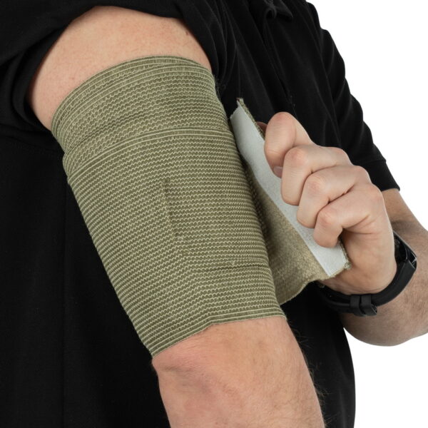 469447 BCB Combat eerste veldverband PF119A6 <big><strong>Kenmerken:</strong> Totale omvang van het verband uitgerekt: 3.5m Verpakkingsgrootte: 11 x 21 cm Latexvrij Vacuüm verzegeld Waterdicht verpakt Gemakkelijk te scheuren verpakking (inkepingen) Steriel Groen/Olijfgroen verband CE-gemarkeerd</big> <big>Gebruiksaanwijzing (afbeeldingen op achterzijde verpakking):</big> <ul> <li><big>Breng het witte kompres aan op de wond</big></li> <li><big>Raak het witte kompres niet aan</big></li> <li><big>Wikkel het elastische verband strak om het ledemaat of lichaamsdeel</big></li> <li><big>Maak de uiteinden van de sluitstrip vast in het verband.</big></li> </ul>