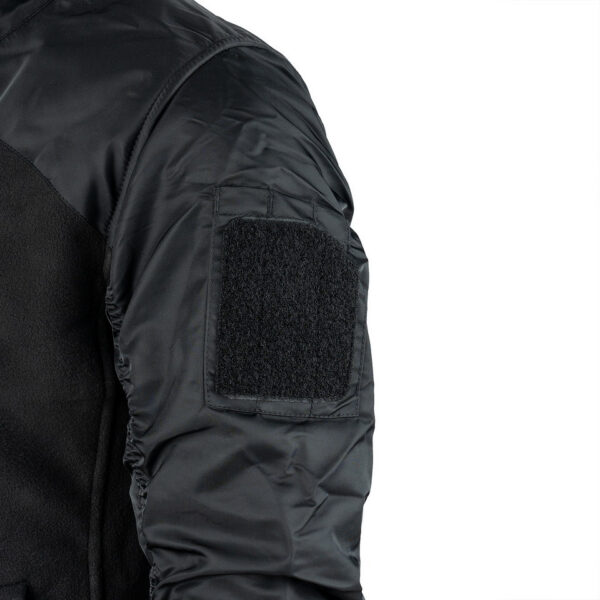 MA 1 Fleece Bomber Jacket12 De MA-1 Fleece Bomber Jacket combineert het beste van twee werelden: het comfort van een fleecejack en het iconische ontwerp van het MA-1 Bomberjack. Dit jack is gemaakt van superzachte fleece met nylon mouwen, waardoor het zowel warm als duurzaam is. Het jack is voorzien van een hoge kraag die extra bescherming biedt tegen de wind, perfect voor koude en winderige dagen. Het MA-1 Fleece Bomber Jacket is uitgerust met premium SBS ritsen voor soepele en betrouwbare sluiting. Twee zakken met ritssluiting aan de voorkant bieden voldoende opbergruimte voor je essentials, terwijl een borstzak met ritssluiting een handige plek biedt voor kleinere items. Het tijdloze ontwerp en de hoogwaardige materialen maken dit jack een uitstekende keuze voor dagelijks gebruik.